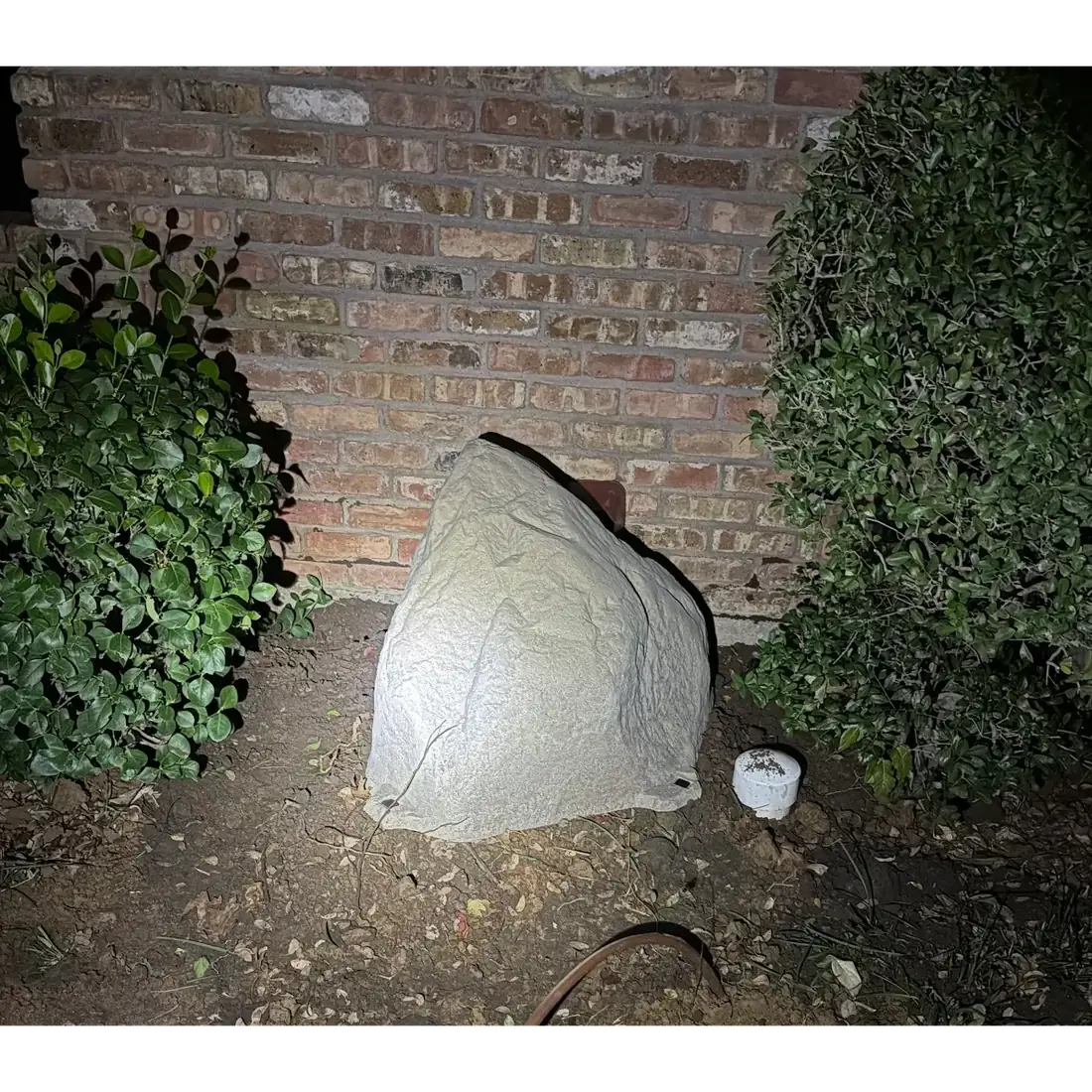 CleanLine Water Co. faux rock enclosure covering an outdoor water softener and filtration system at a Central Texas home, protecting the tanks from sun, freeze and view from the street