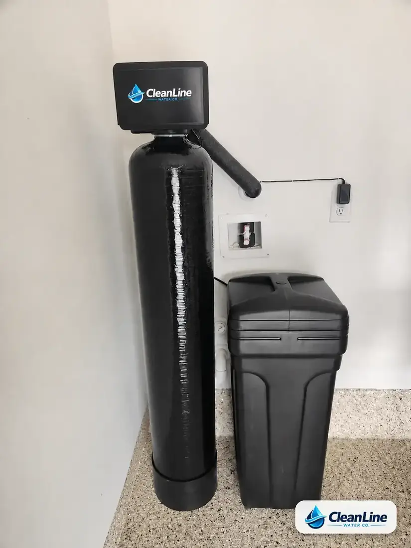 CleanLine Water Co. whole-home water softener and brine tank plumbed into the recessed softener loop box of a Central Texas home